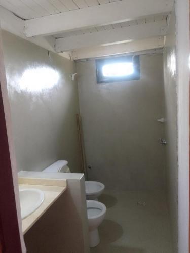 a bathroom with two toilets and two sinks and a window at La Pasiva in Villa Giardino