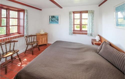 1 dormitorio con 1 cama y 2 sillas en 4 Bedroom Stunning Home In Sams, en Brundby