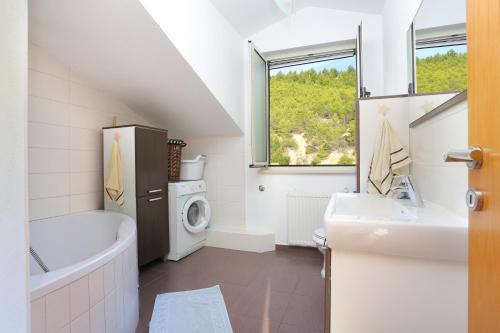 La salle de bains est pourvue d'un lavabo et d'un lave-linge. dans l'établissement Apartments with a parking space Dugi Rat, Omis - 11443, à Dugi Rat