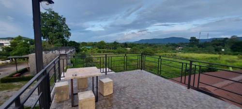 a bench on a balcony with a view of a field at 4 Corner Khaoyai in Mu Si