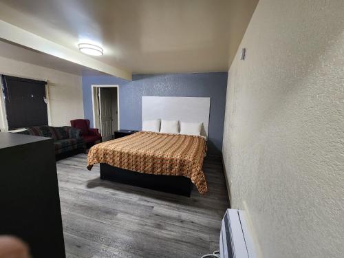 Habitación de hotel con cama y sofá en Green Garden Inn en Greensboro