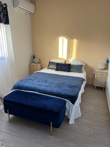 a bedroom with a large bed with a blue blanket at Villa Belle Ile en Mer in Capesterre-de-Marie-Galante