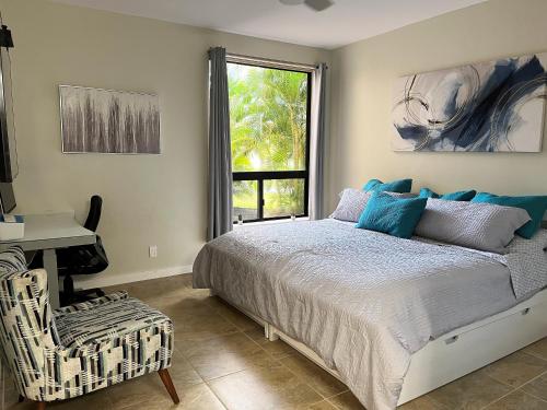 a bedroom with a bed and a desk and a window at Coconut at Shores - Waikoloa Beach Resort in Waikoloa