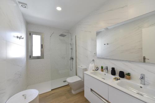 a white bathroom with a toilet and a sink at Apartamento Starlight La Aldea I in San Nicolás