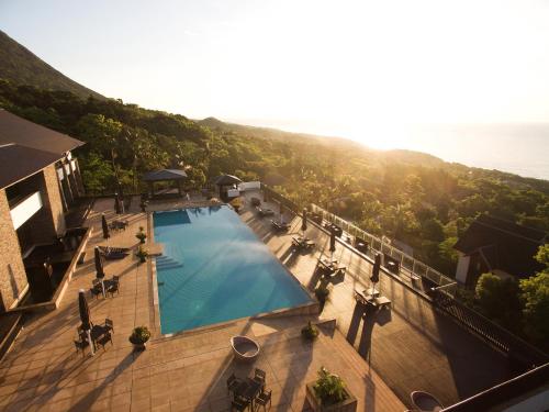 an overhead view of a swimming pool with the ocean in the background at Sankara Hotel & Spa Yakushima in Yakushima