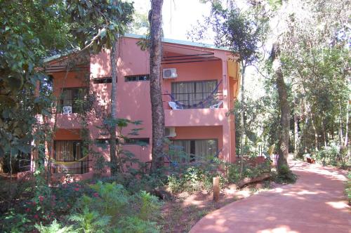 a pink building with trees in front of it at Hotel Sol Cataratas in Puerto Iguazú