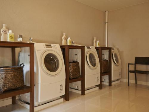 three washing machines are lined up in a room at Sankara Hotel & Spa Yakushima in Yakushima