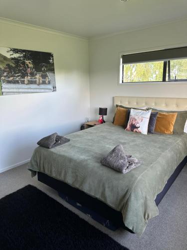 um quarto com uma cama grande e uma janela em A Place in the Paddock em Matamata