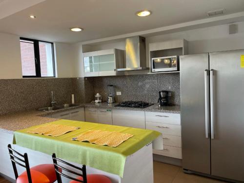 cocina con mesa y nevera en Apartamento Quito tenis, en Quito