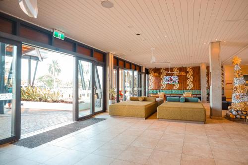 a living room with couches and a christmas tree at Lava Hotel in Apia