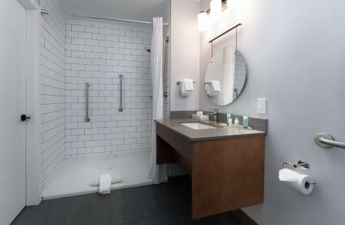 a bathroom with a sink and a shower and a mirror at Prestige Kamloops Hotel in Kamloops