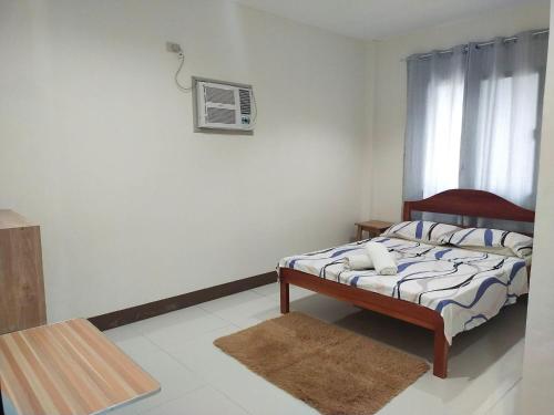 a small bedroom with a bed and a window at Junie Pension House in Moalboal
