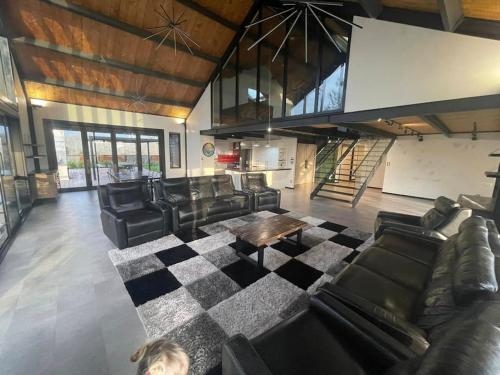 a living room with leather furniture and a checkered floor at The clubhouse in Hamilton