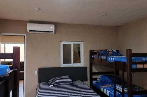 a room with three bunk beds and a window at Casa de playa Tortugas Place. in Escuintla
