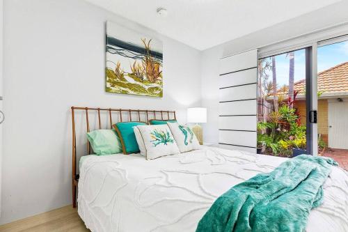 a bedroom with a bed and a large window at Luxury Beach Front Apartment in Urangan