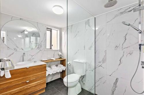 a bathroom with a shower and a toilet and a sink at Luxury Beach Front Apartment in Urangan