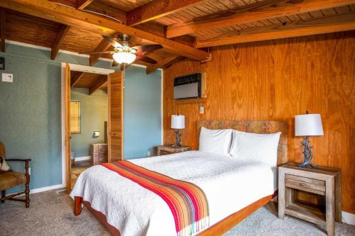 a bedroom with a white bed and wooden walls at Lakeside Escape in Lakehills