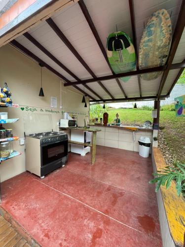 an outdoor kitchen with a stove and a counter at Hostel Antônio Pescador Guarda do Embau in Guarda do Embaú