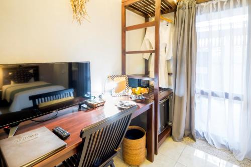 a room with a desk with a bed and a desk sidx sidx sidx at Cocotinos Lembeh a Boutique Dive Lodge in Bitung