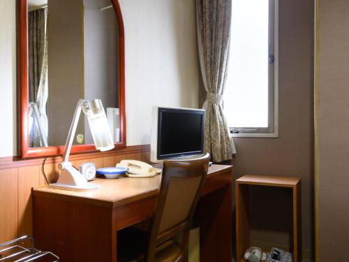 un escritorio con ordenador y monitor en Business Ryokan Hotel Yukimiso, en Toyama