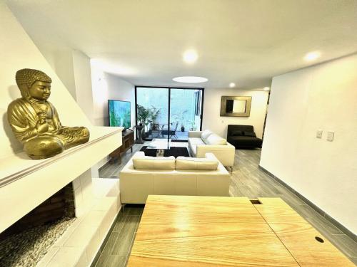 uma sala de estar com uma estátua sentada numa parede em C22-2 Hermoso departamento con Terraza em Cidade do México