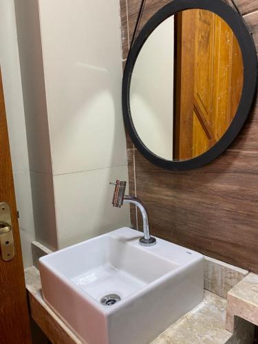 uma casa de banho com um lavatório e um espelho em Temporada Serrana em Guaramiranga