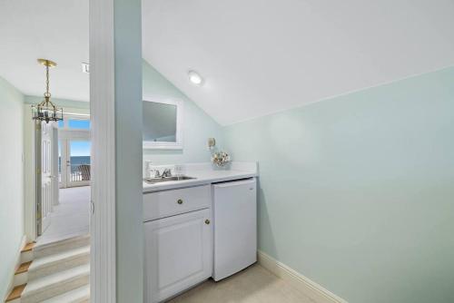 a white kitchen with a sink and a hallway at Oceanfront/Zero Steps to Beach/Views/4BR in Gulf Shores