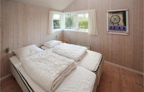 een slaapkamer met een bed en een klok aan de muur bij Awesome Home In Sams With Kitchen in Nordby