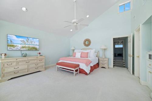 a bedroom with a bed and a dresser and a tv at Oceanfront/Zero Steps to Beach/Views/4BR in Gulf Shores