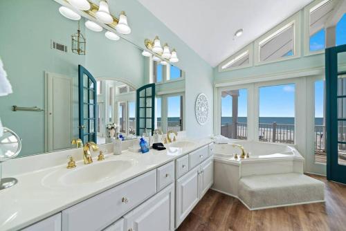 a bathroom with two sinks and a tub and windows at Oceanfront/Zero Steps to Beach/Views/4BR in Gulf Shores