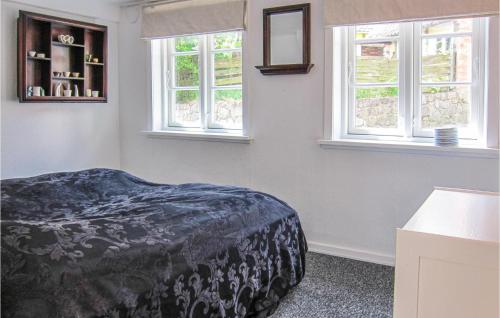 1 dormitorio con 1 cama y 2 ventanas en Pet Friendly Apartment In Gudhjem With House Sea View, en Gudhjem