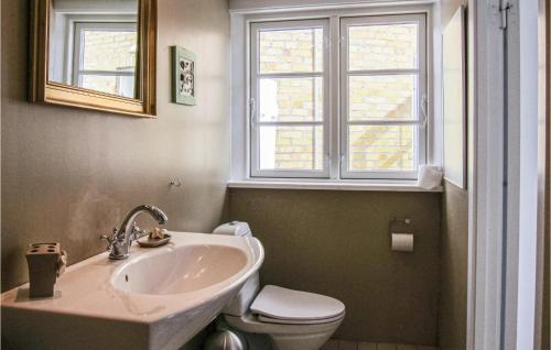 baño con lavabo y aseo y ventana en Pet Friendly Apartment In Gudhjem With House Sea View, en Gudhjem