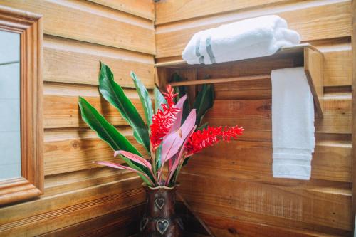 a bathroom with a vase with a flower in it at Jaguar Creek in Good Living Camp