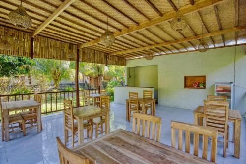 a restaurant with wooden tables and chairs on a patio at Puri Yalus Bungalow in Nusa Penida