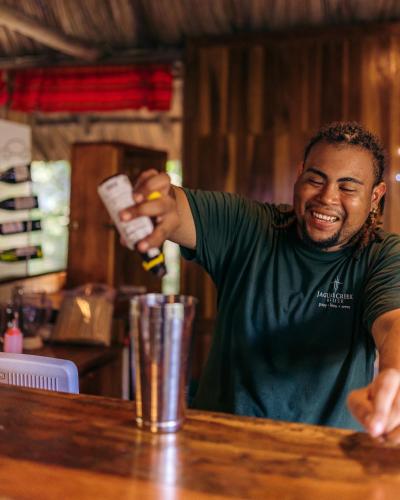 a man sitting at a bar holding a drink at Jaguar Creek in Good Living Camp