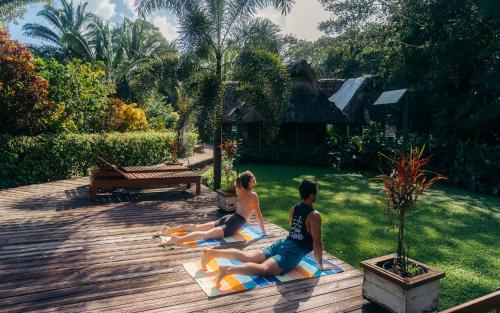 two people sitting on a yoga mat in the yard at Jaguar Creek in Good Living Camp