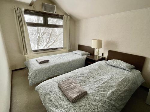 八幡平市にある19 Accommodationの窓のある部屋にベッドが2つある