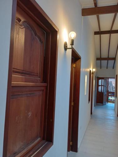 a hallway with a wooden door and a hallway with a hallwayngth at Hostal Famihotel Fundadores in Jardin