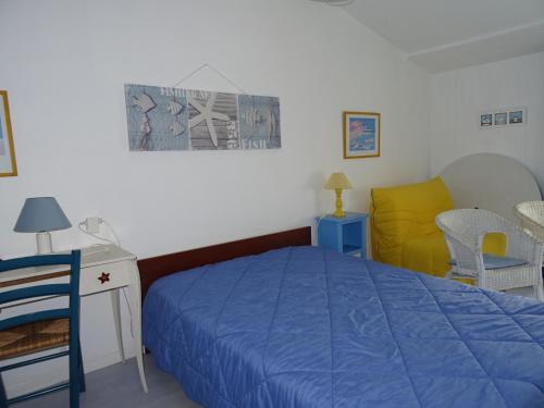 1 dormitorio con 1 cama azul y 1 silla amarilla en Maison Les Sables-d'Olonne, 3 pièces, 4 personnes - FR-1-92-663, en Les Sables-dʼOlonne