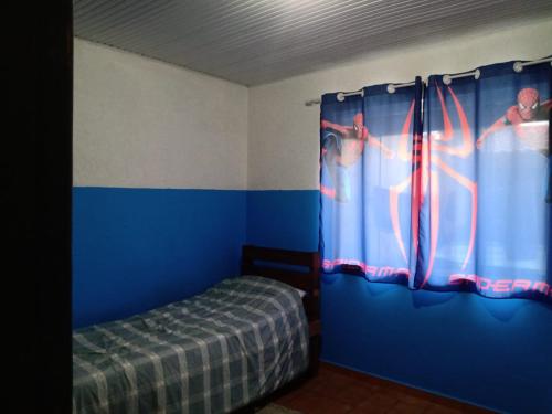 馬蒂尼奧斯的住宿－anderson，一间卧室设有一张床和蓝色的墙壁