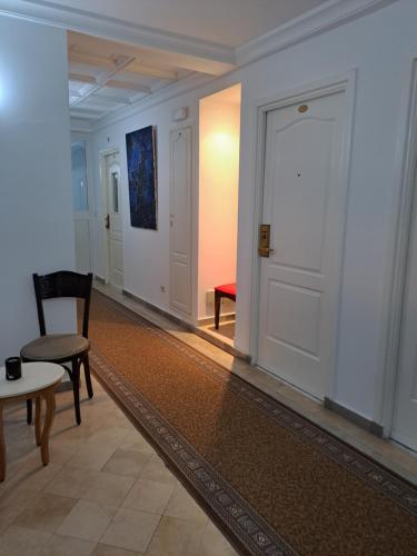 a hallway with a door and a chair and a table at HOTEL LAFAYETTE in Tunis