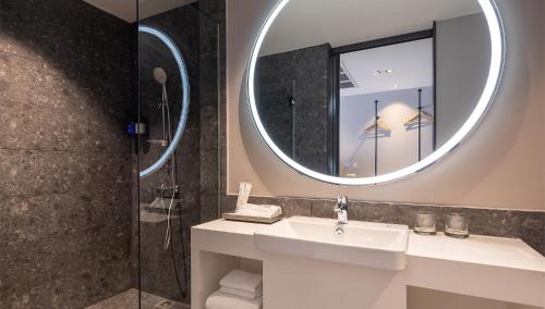 a bathroom with a sink and a mirror at Travelodge Nimman in Chiang Mai