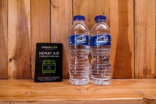 dos botellas de agua sentadas junto a un libro en Urbanview Villa Kolopaking Kebumen by RedDoorz, en Kebumen