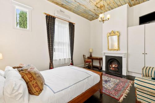 a bedroom with a bed and a fireplace at WARATAH at Queenscliff in Queenscliff
