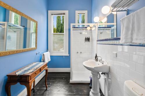 a blue bathroom with a sink and a mirror at WARATAH at Queenscliff in Queenscliff