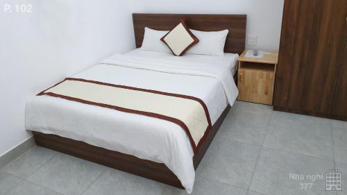 a bedroom with a large bed with white sheets at Vy An Hotel in Bao Loc