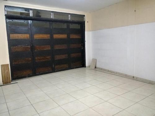 una habitación vacía con un garaje con una puerta grande en Departamento en Godoy Cruz