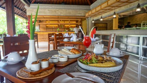 a table with food on it in a restaurant at Sakti Garden Resort & Spa in Ubud