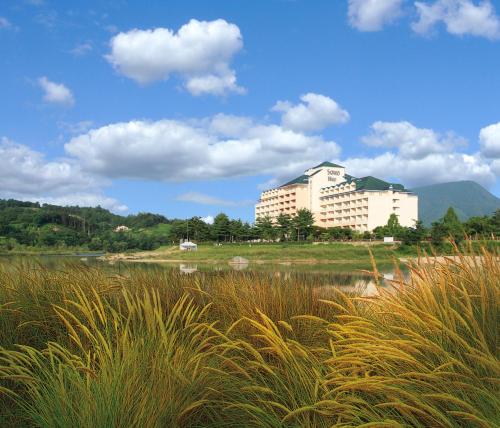 a large building in the middle of a field with tall grass at Sono Belle Yangpyeong in Yangpyeong