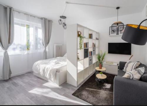 a white bedroom with a bed and a couch at Schickes Appartement an der Neckarpromenade in Heilbronn